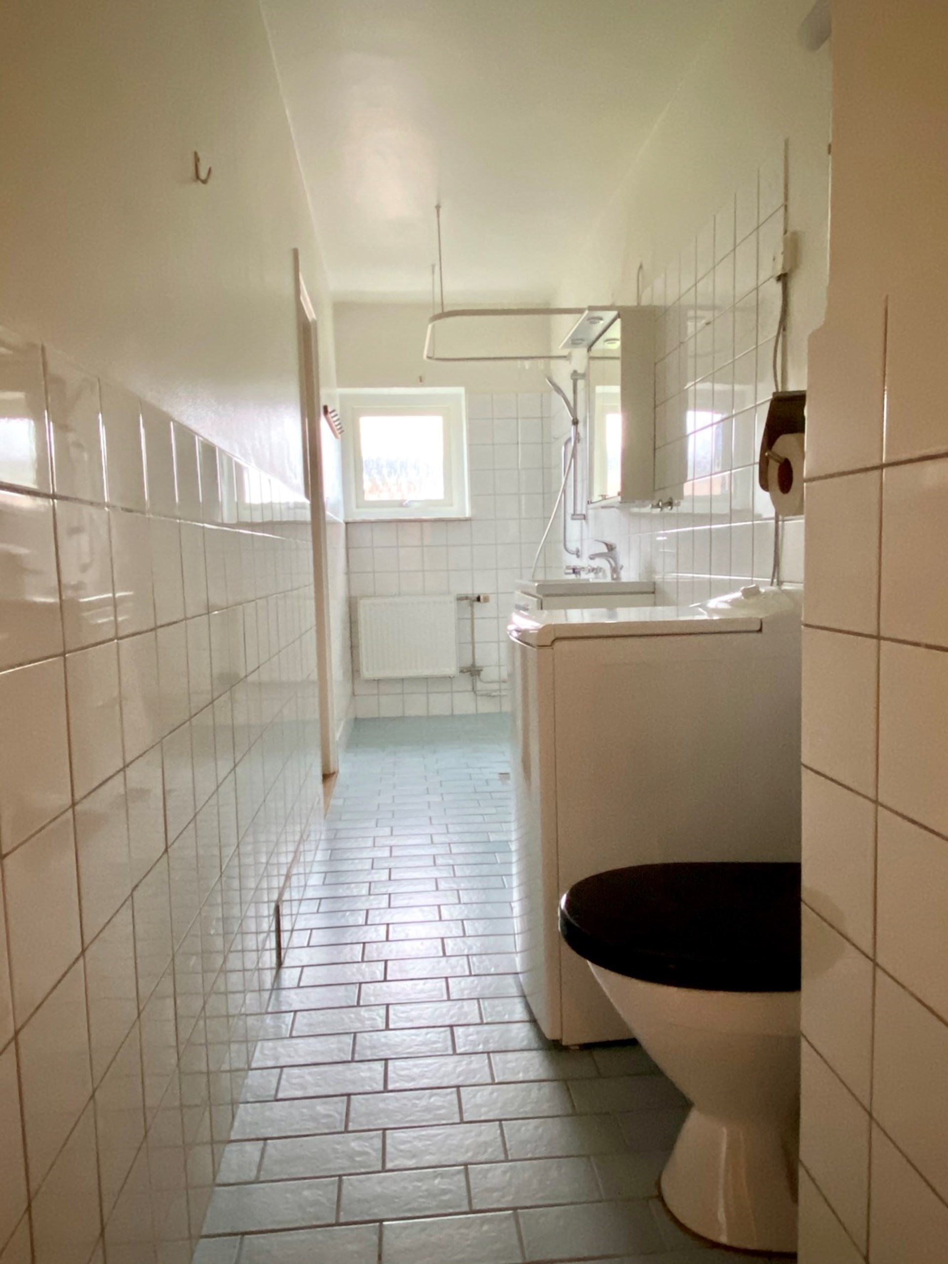 Badrum med tvättmaskin och dusch